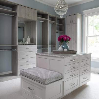 blue walls with gray cabinetry an island and a seat