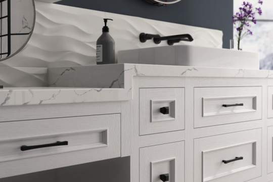 A white kitchen sink with a marble countertop, a mirror, and a soap dispenser, creating a clean and elegant atmosphere.