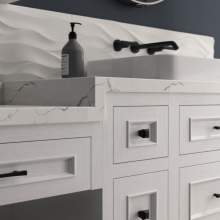 A white kitchen sink with a marble countertop, a mirror, and a soap dispenser, creating a clean and elegant atmosphere.