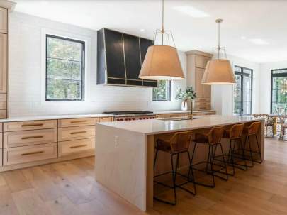 light wood kitchen with white subway tile backsplash and continous granite island